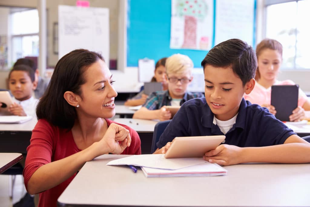 Teacher helping elementary school boy