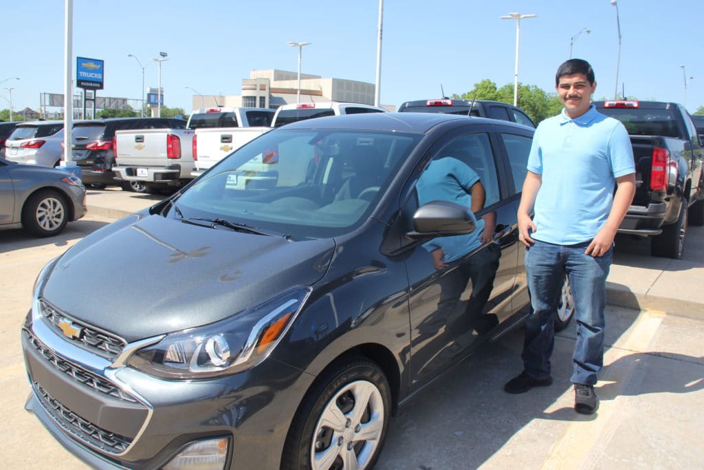 Emilio Ramirez standing next to car