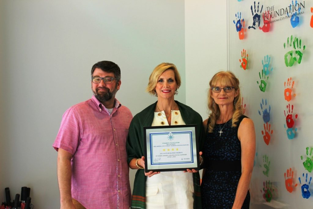 Foundation staff posing with Charity Navigator certificate