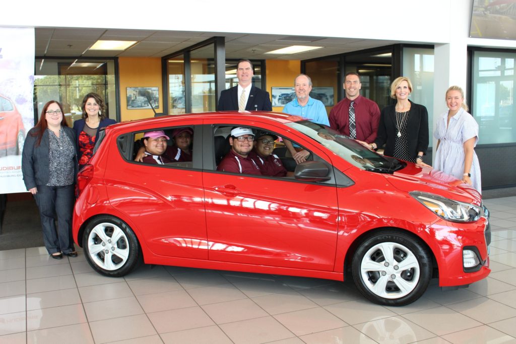 OKCPS and Hudiburg staff with red car