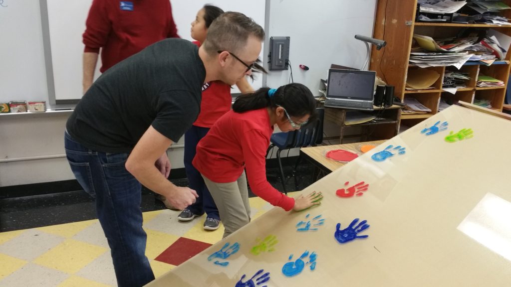 students paint handprints