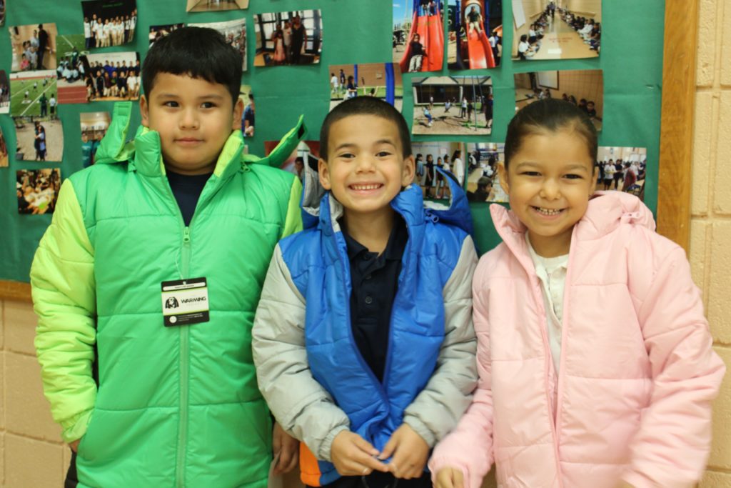 children smiling wearing puffy coats