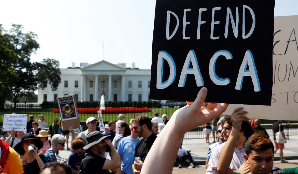 defend daca sign in front of the White House