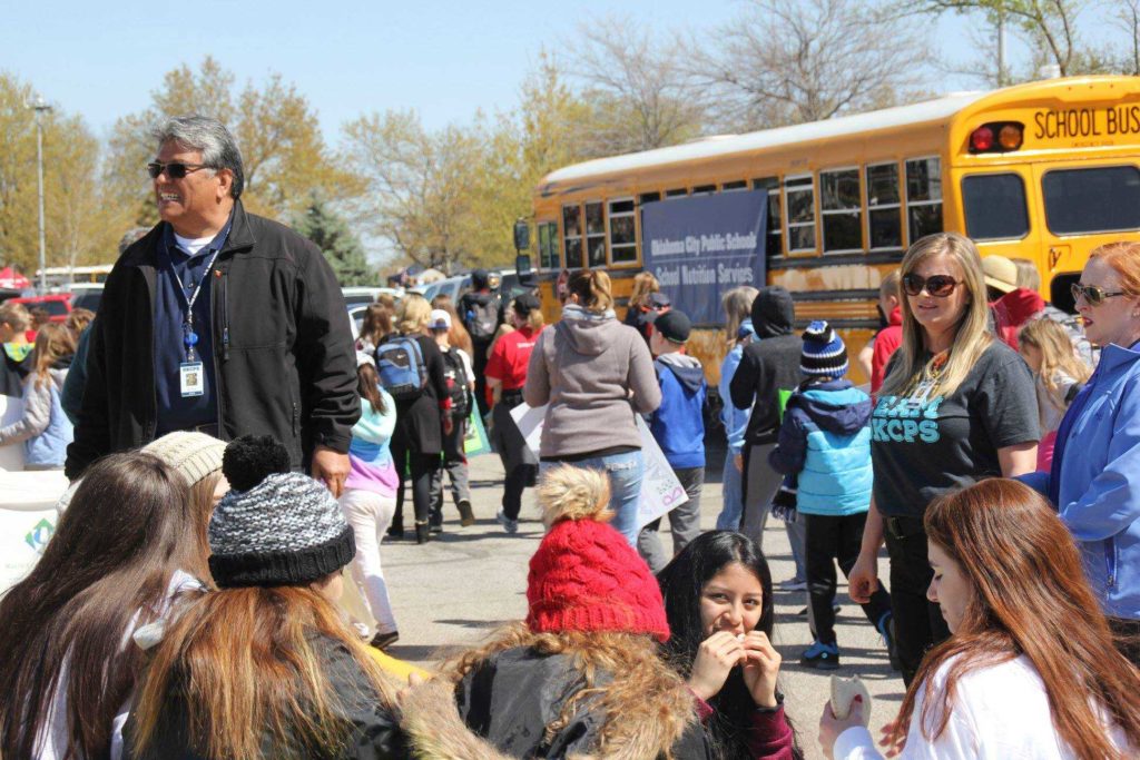 students outside at school with bus in the background