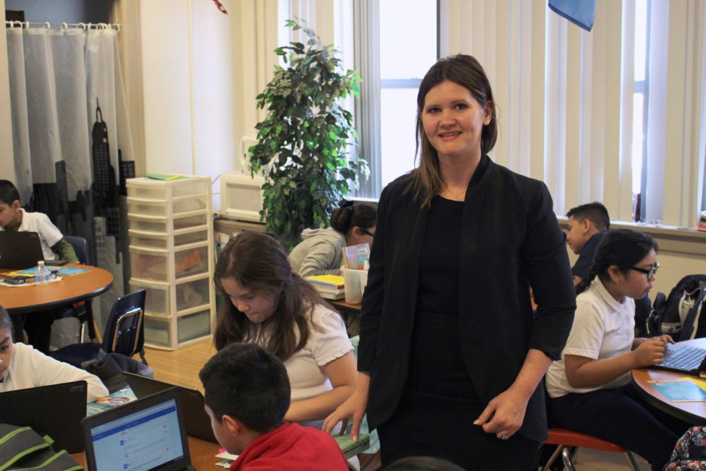 teacher instructing student on computer